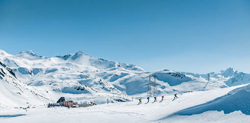 Wintermagazin Titelgeschichte Nord-Sued Winter 2019-20. Skitourengruppe im Aufstieg am Gotthardpass. Winter magazine cover story North-South Winter 2019-20. Ski touring group on the ascent of the Gotthard Pass.