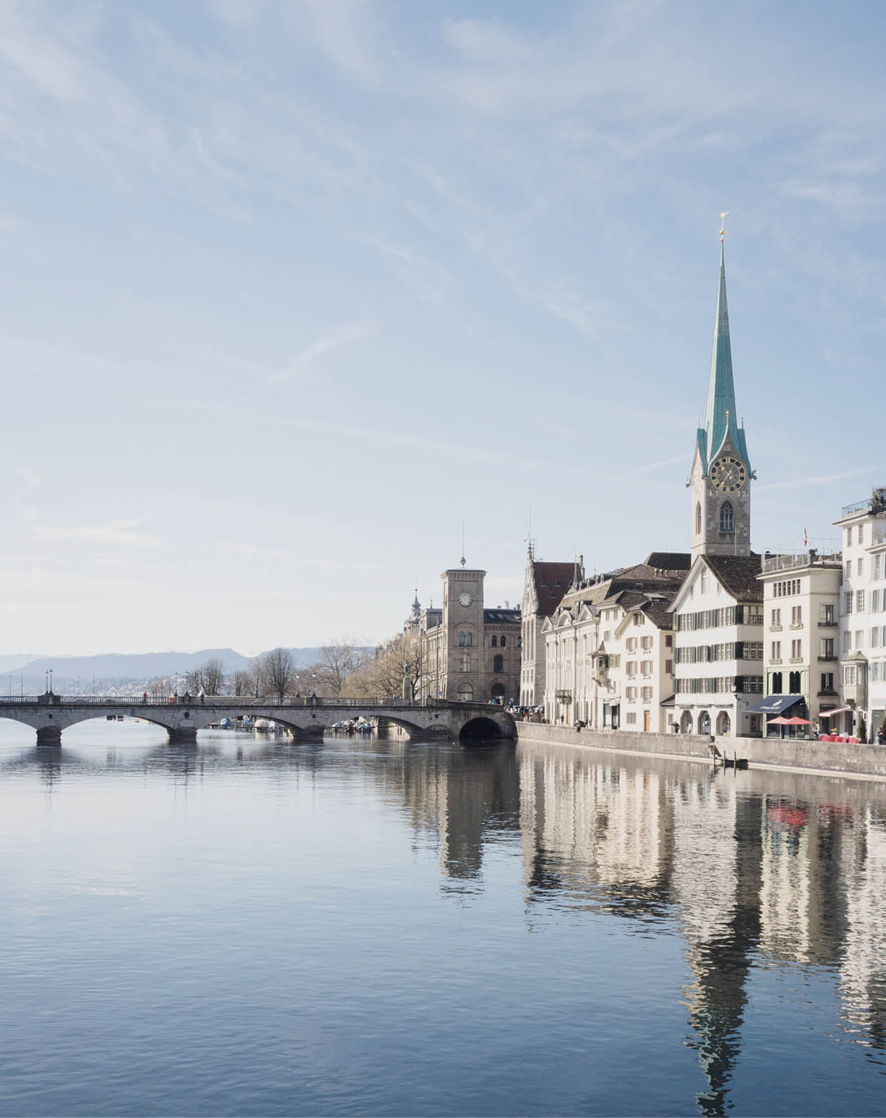 2FN9JH6 Riverfront of the Limmat river at the old town of Zurich, Switzerland. Looking south towards the lake and Fraumunster cathedral